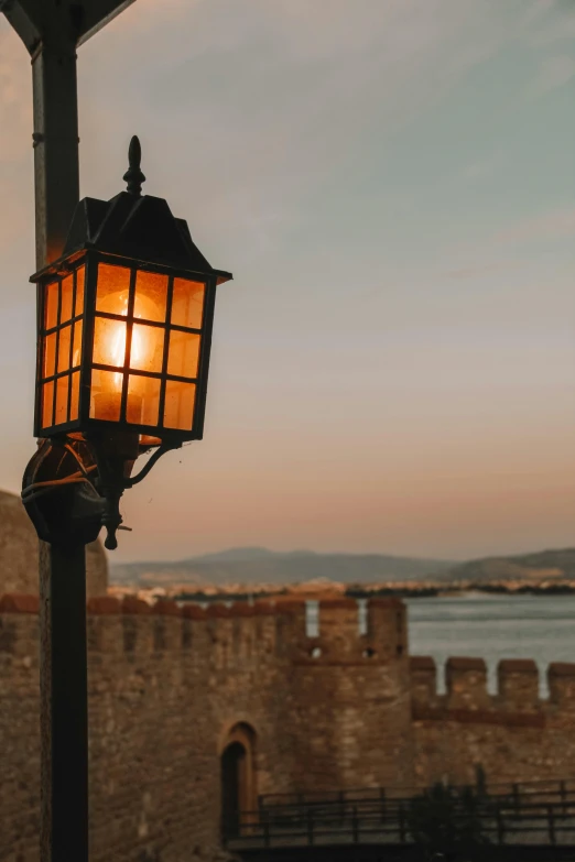 a street light on a pole with water and sky in the background