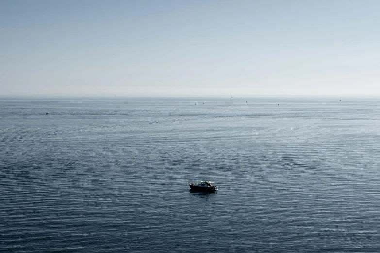 a lone boat floating on top of a body of water