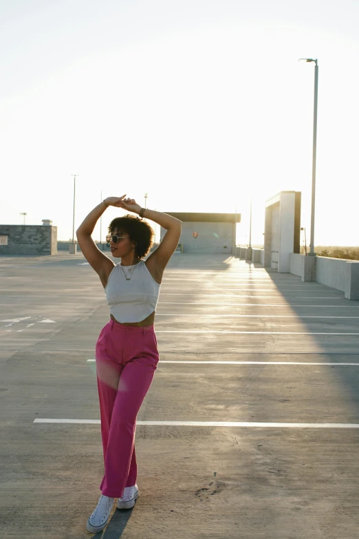 a woman dancing in an empty parking lot