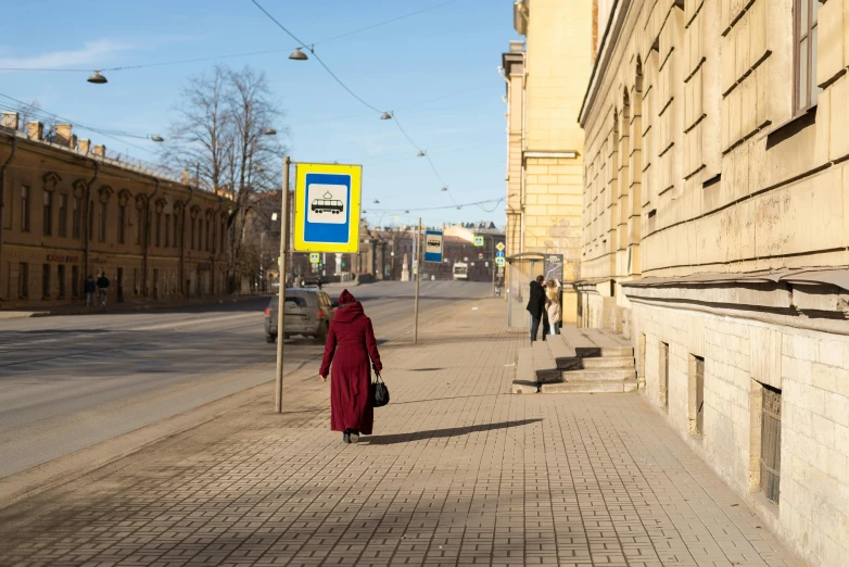 an older person wearing red on the side of a road