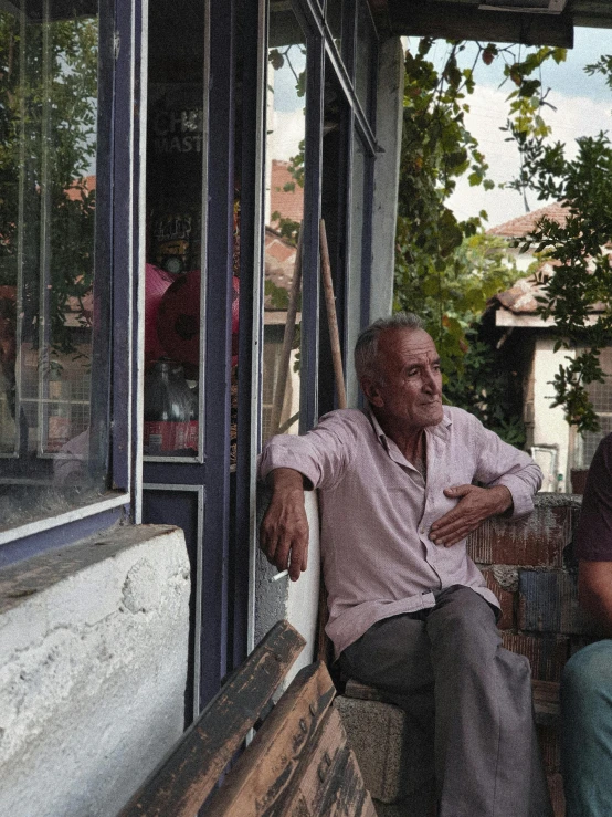 two people are sitting outside looking in the window