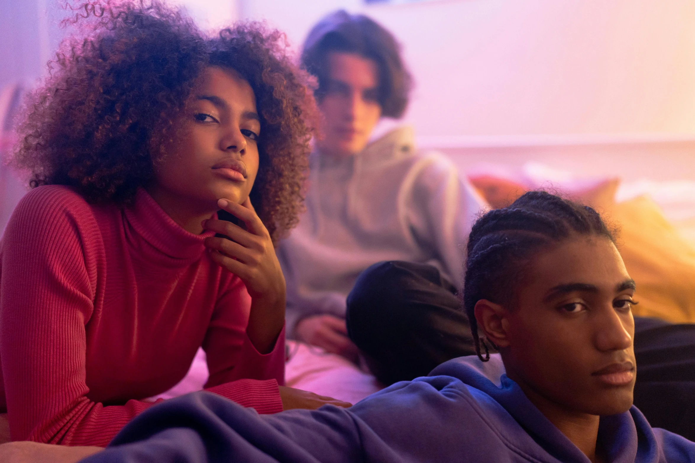 two women and a man sitting on a couch