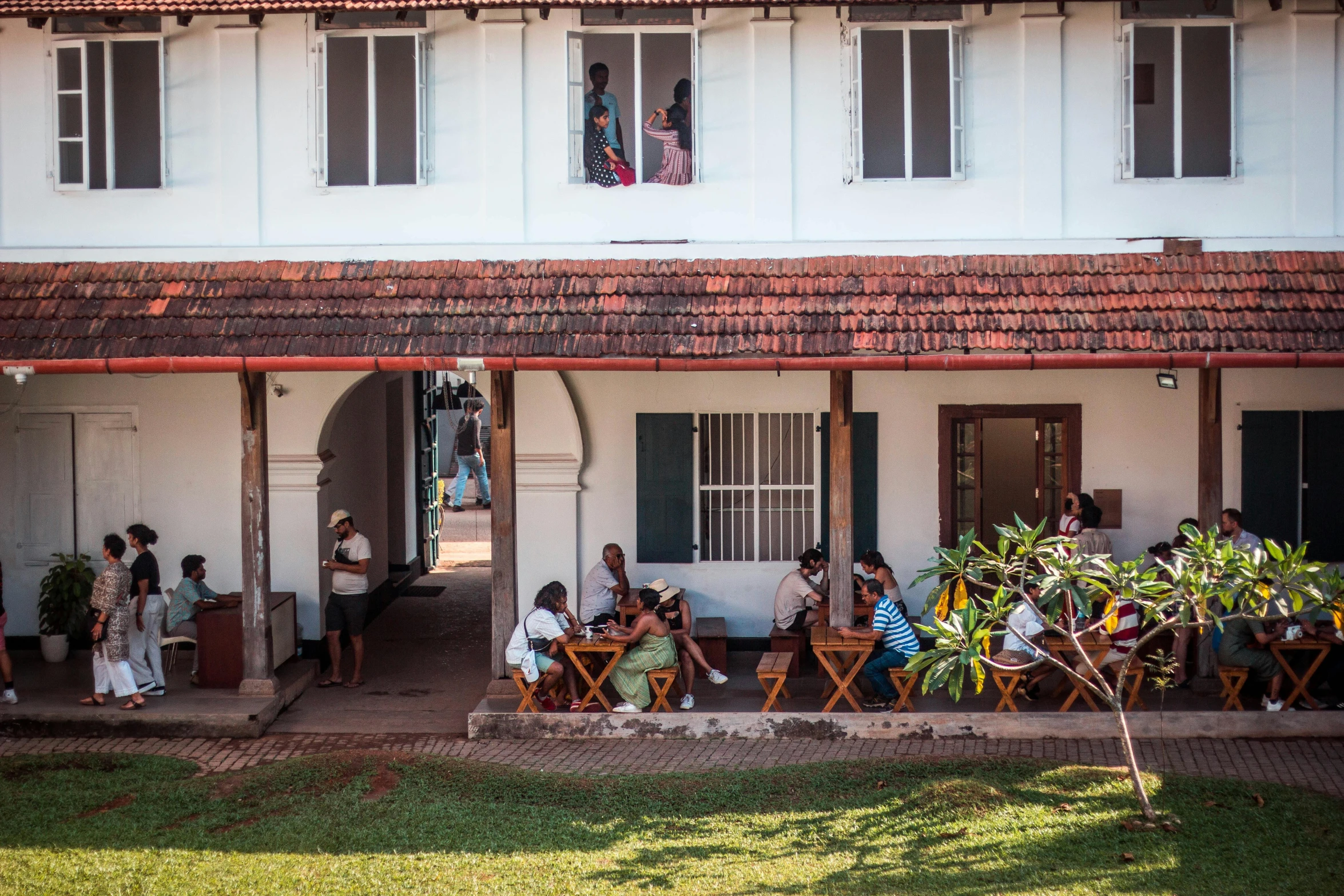 a group of people sitting at a table in a courtyard