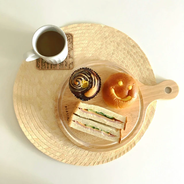 a tray topped with sandwiches and cupcakes on top of a table