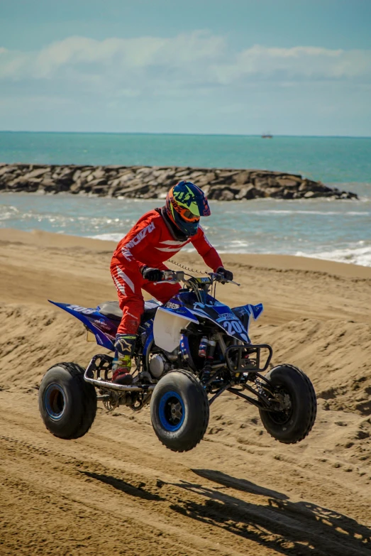 person doing an off - road race on the beach on a four wheeler