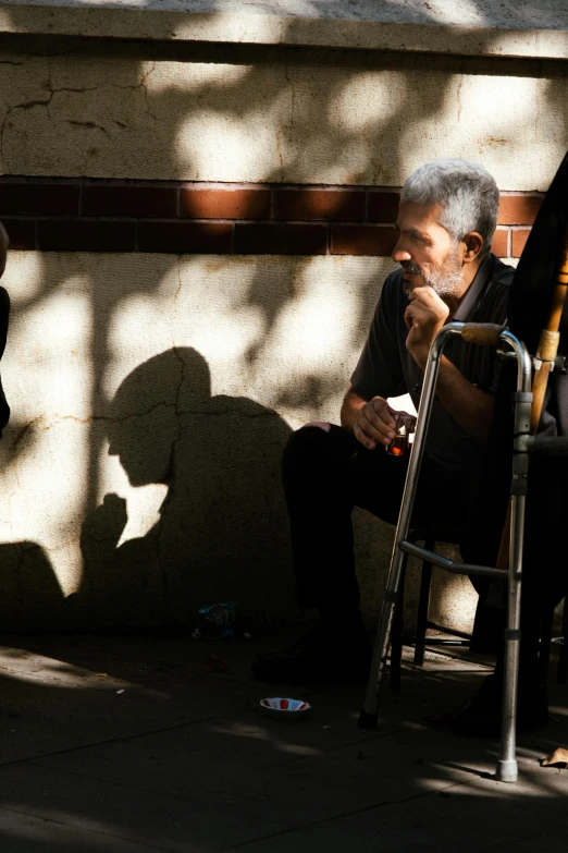 a man smoking a cigarette while sitting on a chair