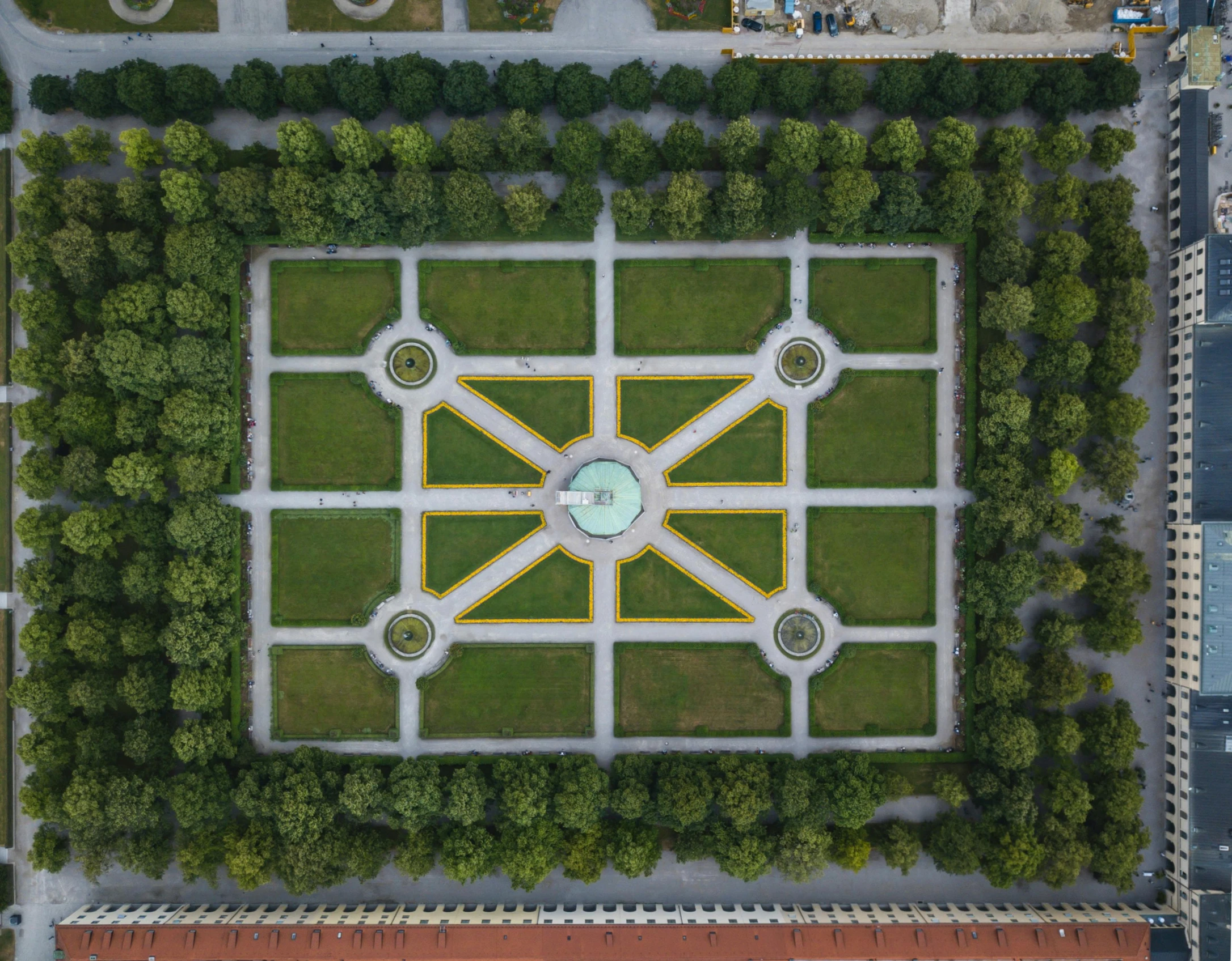 a view from above looking down on an enclosed square with trees and a clock in the middle of the center