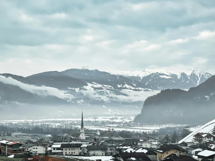 a town under snow covered mountains with buildings and buildings