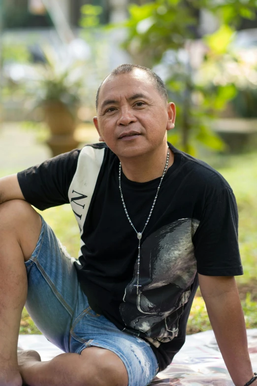 a man in a black shirt and blue jeans is posing for a po