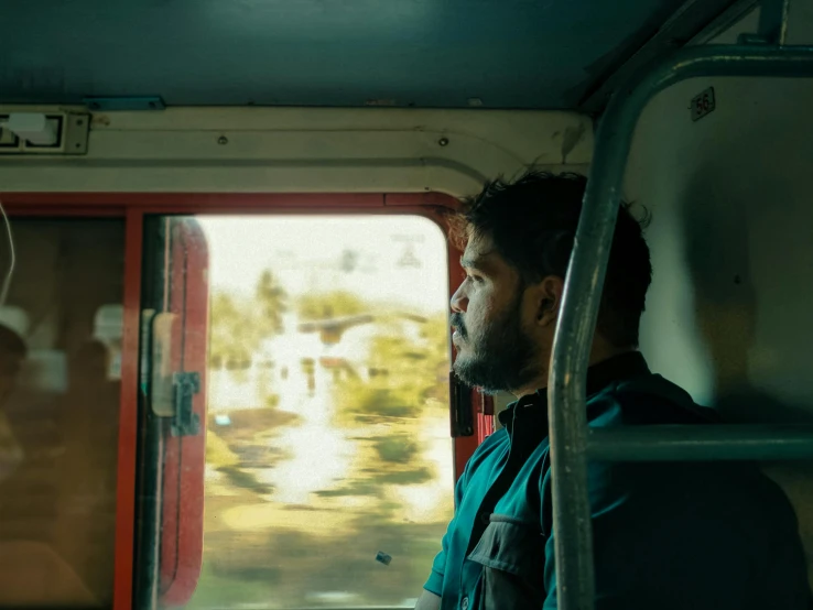 a man is looking out the window on a train