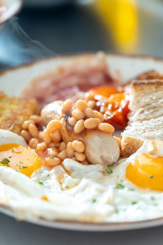 a plate with some eggs, sausages and beans on it