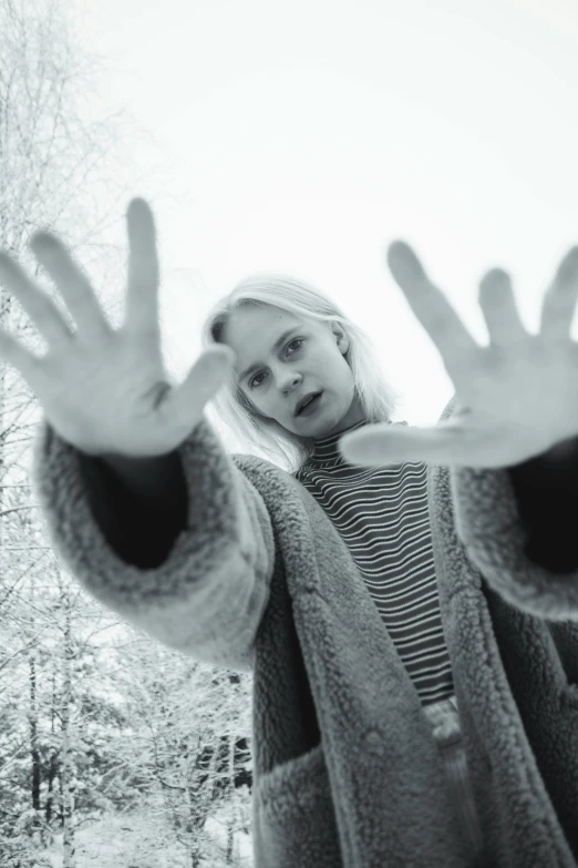 a young woman stands in front of an unfrved snowy forest