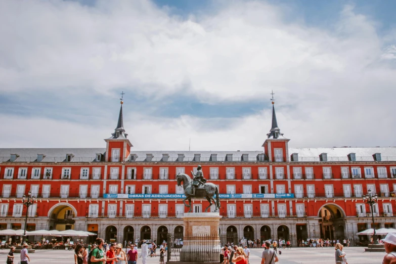 people walking around in front of a red building