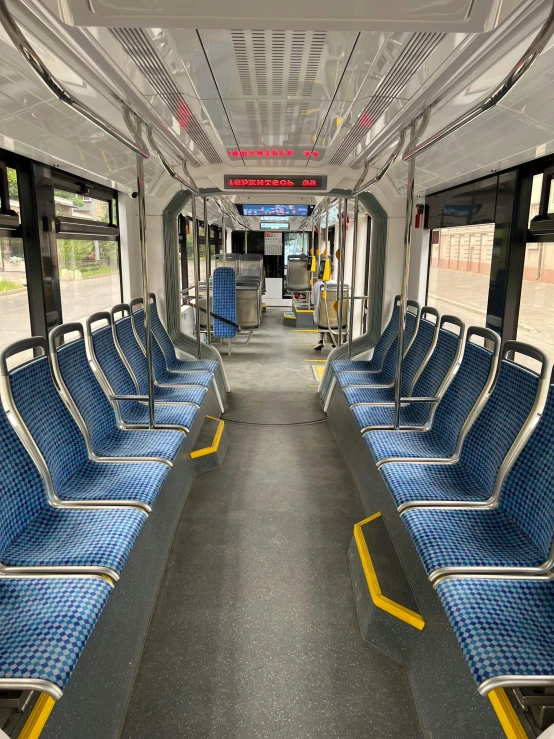 an empty bus with rows of blue seats