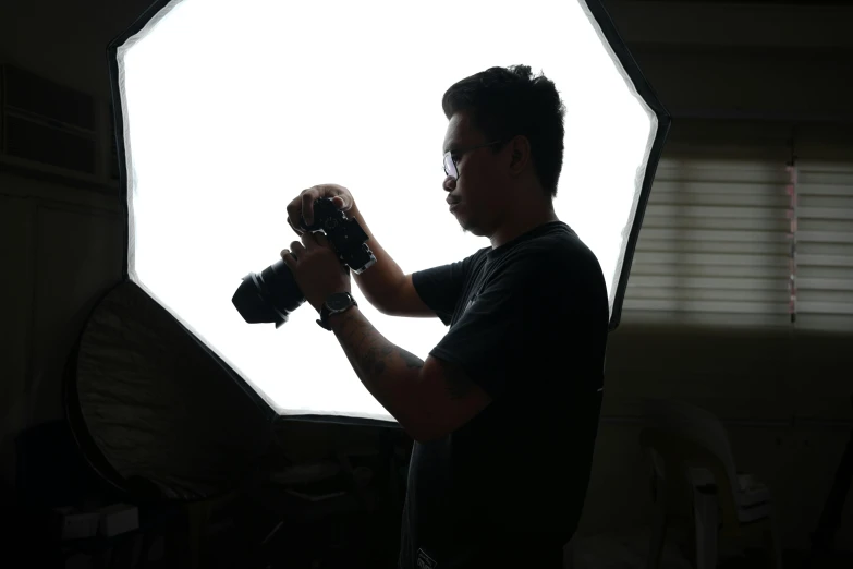 man holding camera and shooting inside of dark room