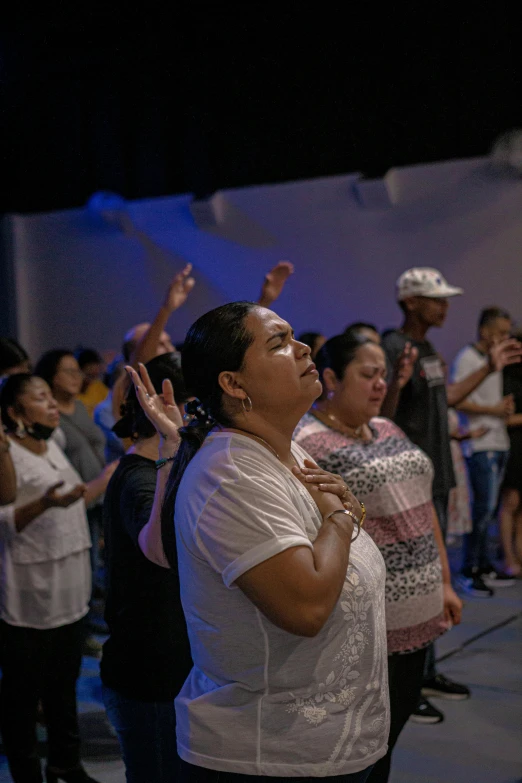 a woman standing in a group clapping with other people behind her