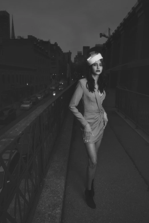 a woman walking across a bridge in a short dress