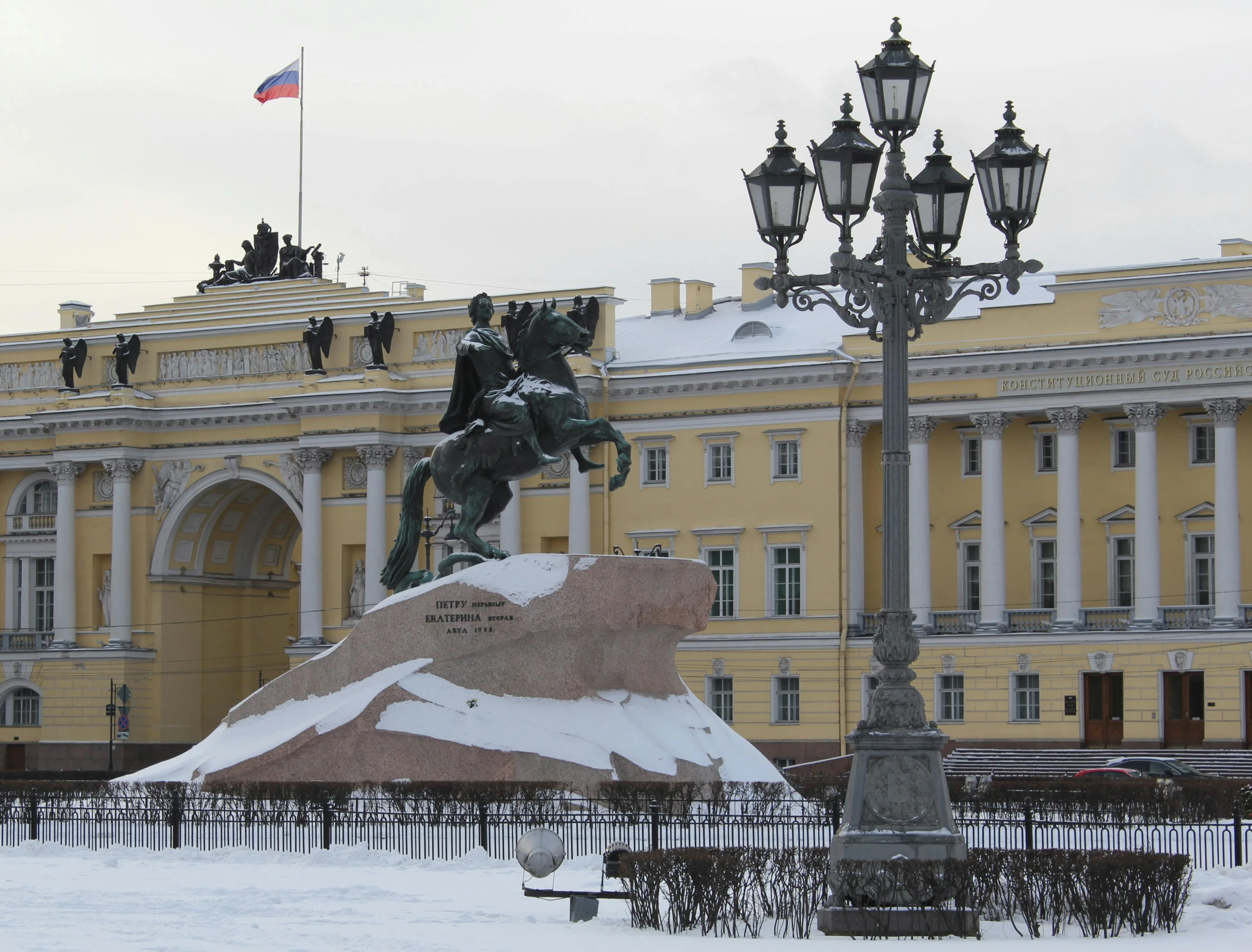 statue in front of large, ornate building with street lamp