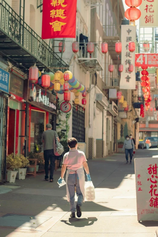 woman walking down a narrow street with many lights hanging