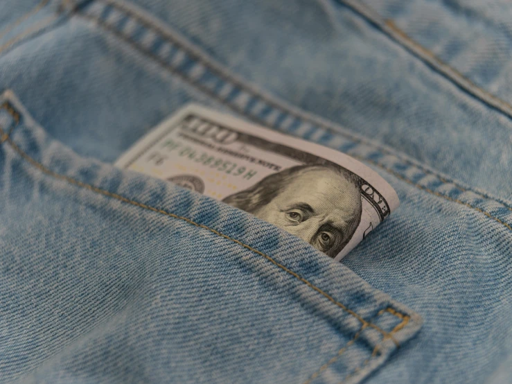 dollars sticking out from a pocket of jeans