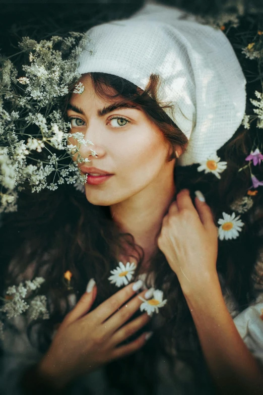 a woman with flowers around her face is surrounded by daisies