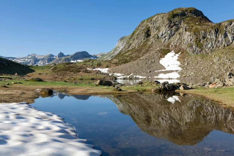 a mountain view with snow on top and water in the bottom