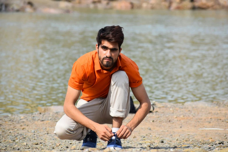 a man kneeling down by the water