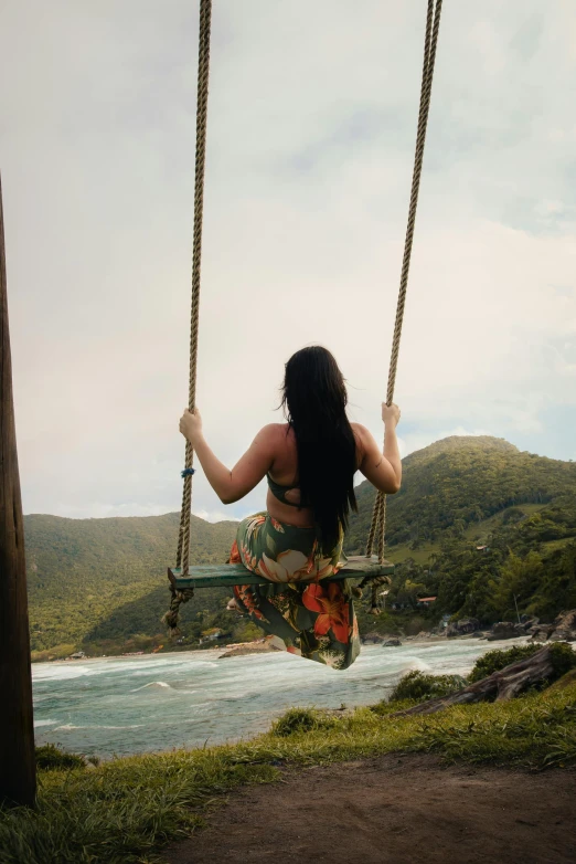 woman in a tropical dress hanging on a swing