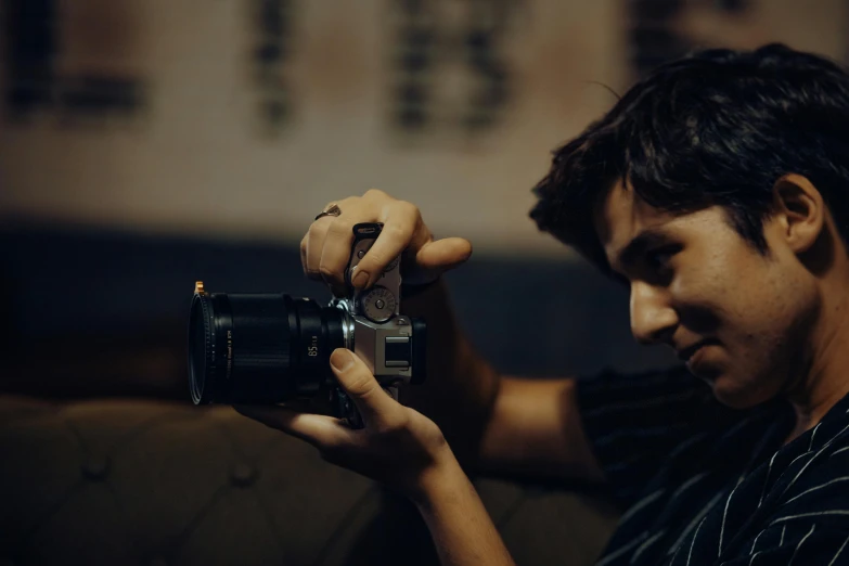 man holding a camera with both hands while looking at it