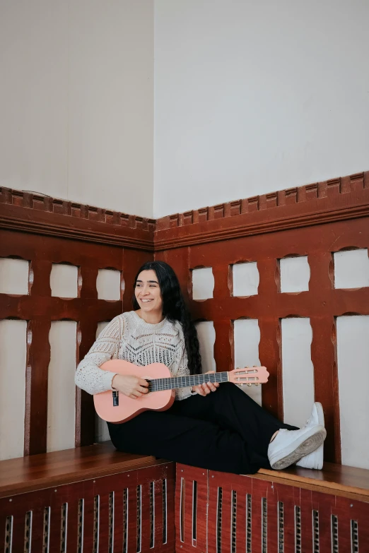 a woman sitting on a bench with a guitar