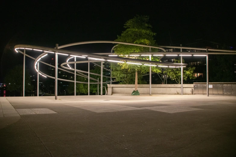 a bench is next to some lights on a dark street