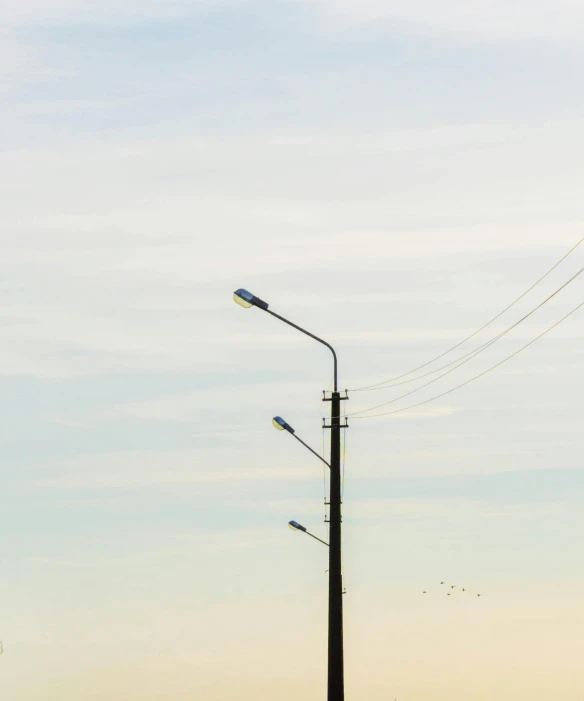 a street lamp sitting above a tall power line