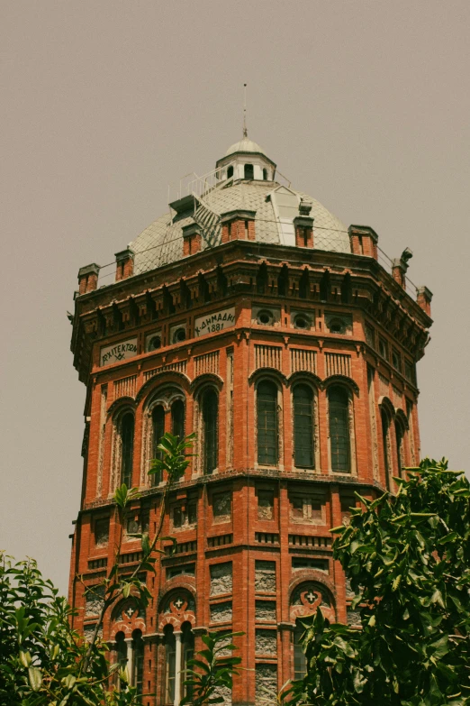 an old brick building surrounded by trees and shrubs