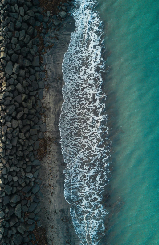 water is pouring out from the sand and rocks into a bay