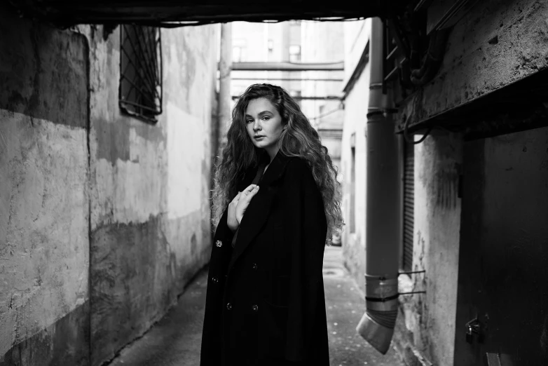 a woman is standing in an alley between two buildings