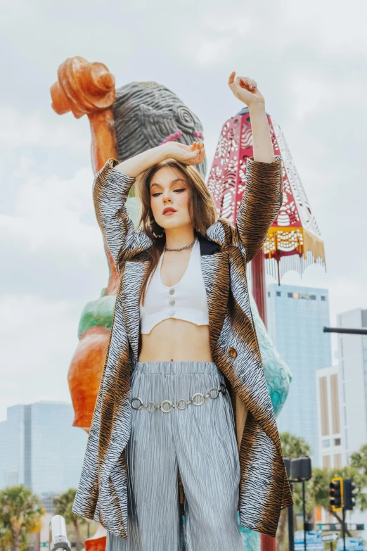 a woman in white crop top standing next to a statue