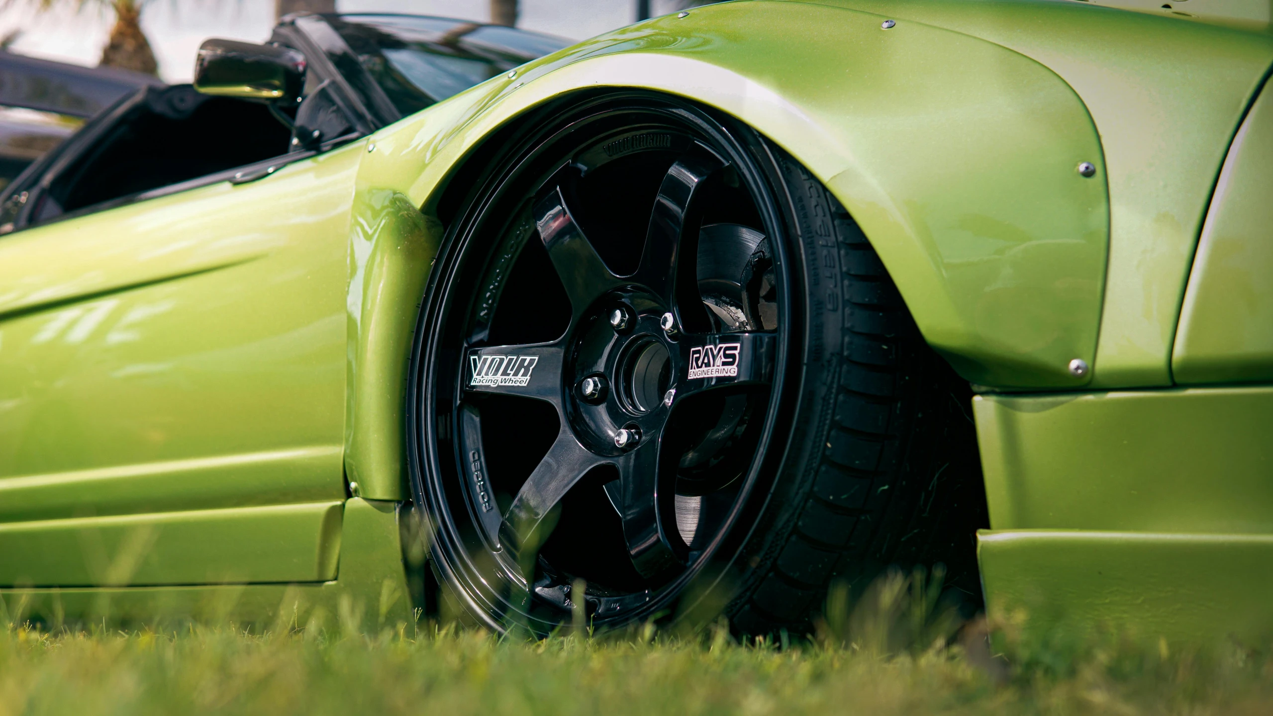 a green sports car parked on the side of the road