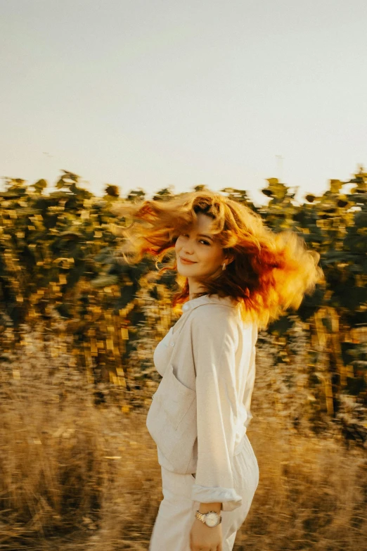 a woman is standing alone in a field with long hair