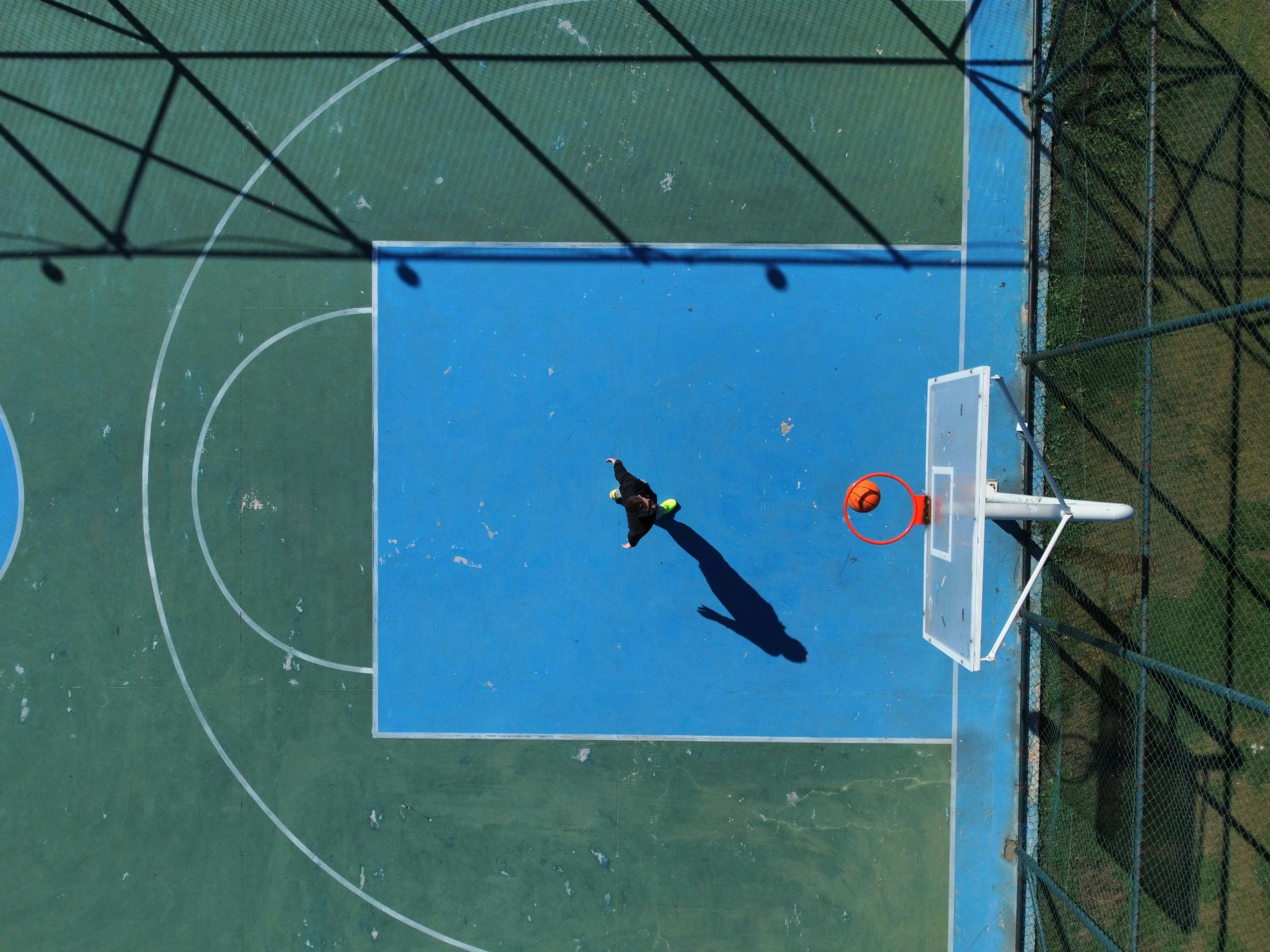 an overhead s of basketball being thrown to an opponent