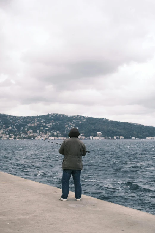 a person standing on a pier next to the ocean