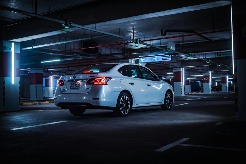 a white car parked in the dark under a green light