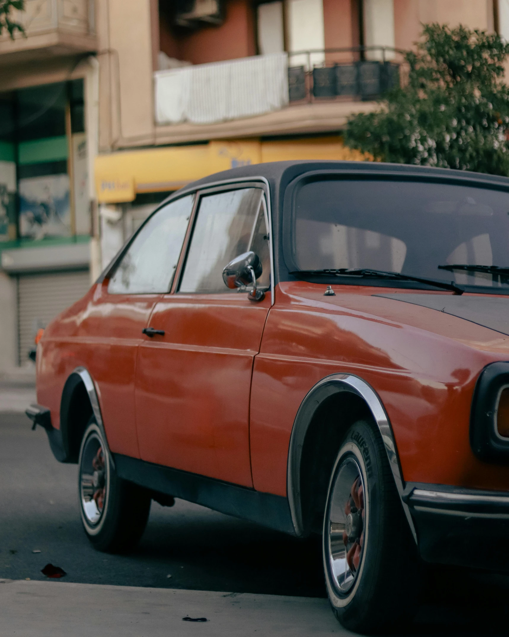 an old red car parked in the street