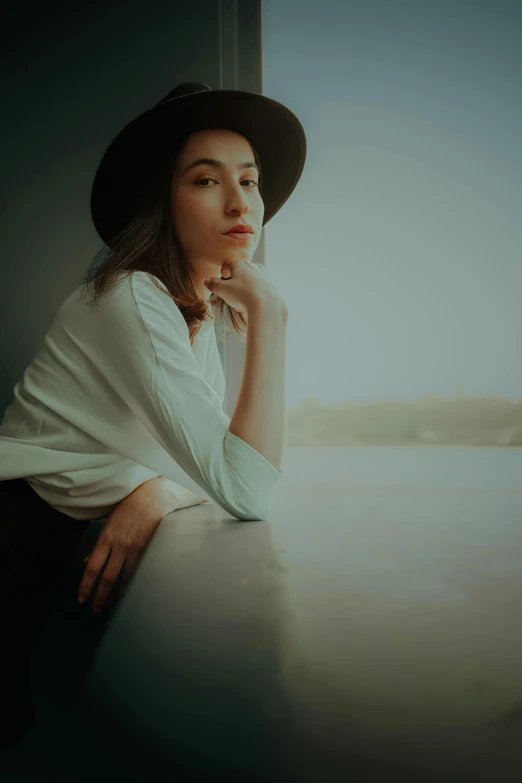 a woman with a hat standing next to water