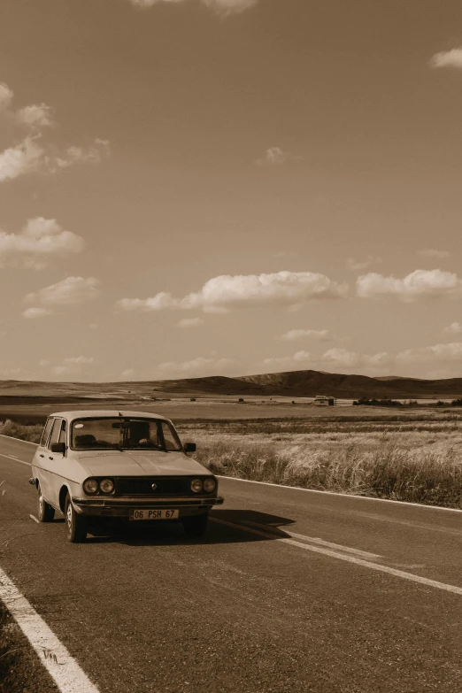 a car driving down a country road in a sepia tone