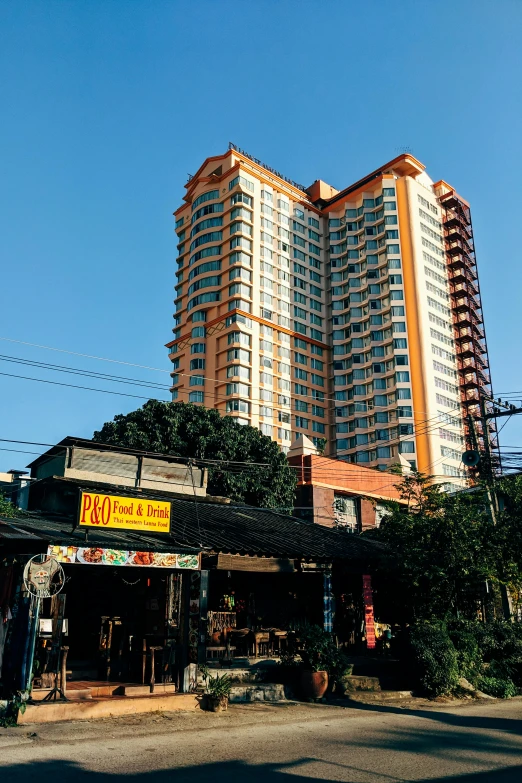 a tall building with many windows in front of a road