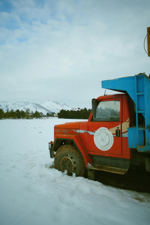 red dump truck parked in snow covered field