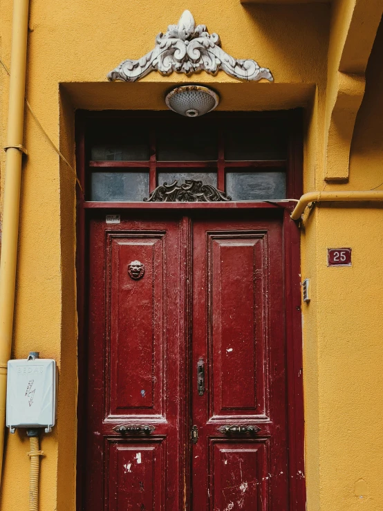 an orange building with two red doors next to a telephone pole