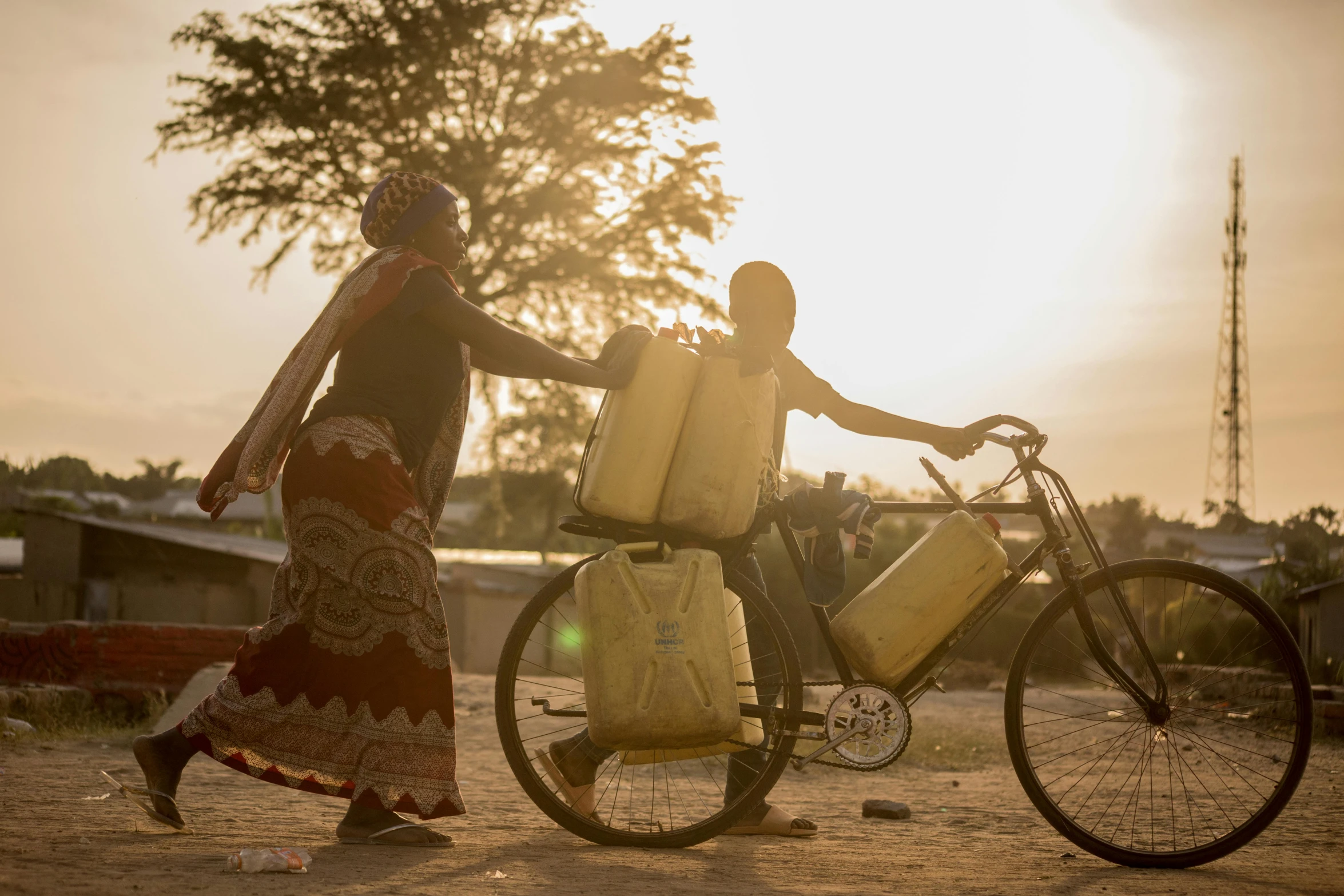 a woman carrying two bags on a bike