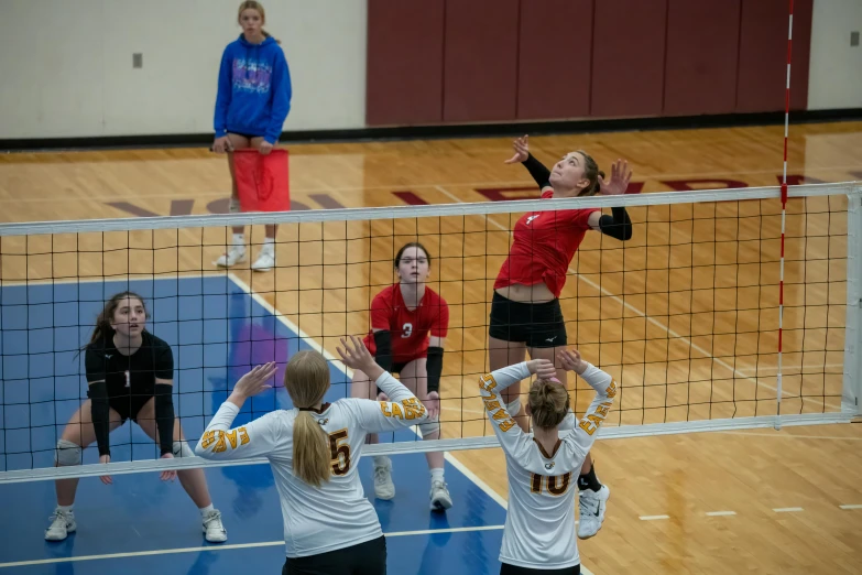 two girls on different teams play volley ball