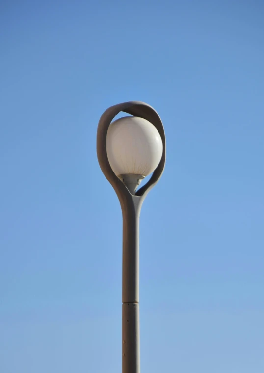 the light post is lit by the clear blue sky